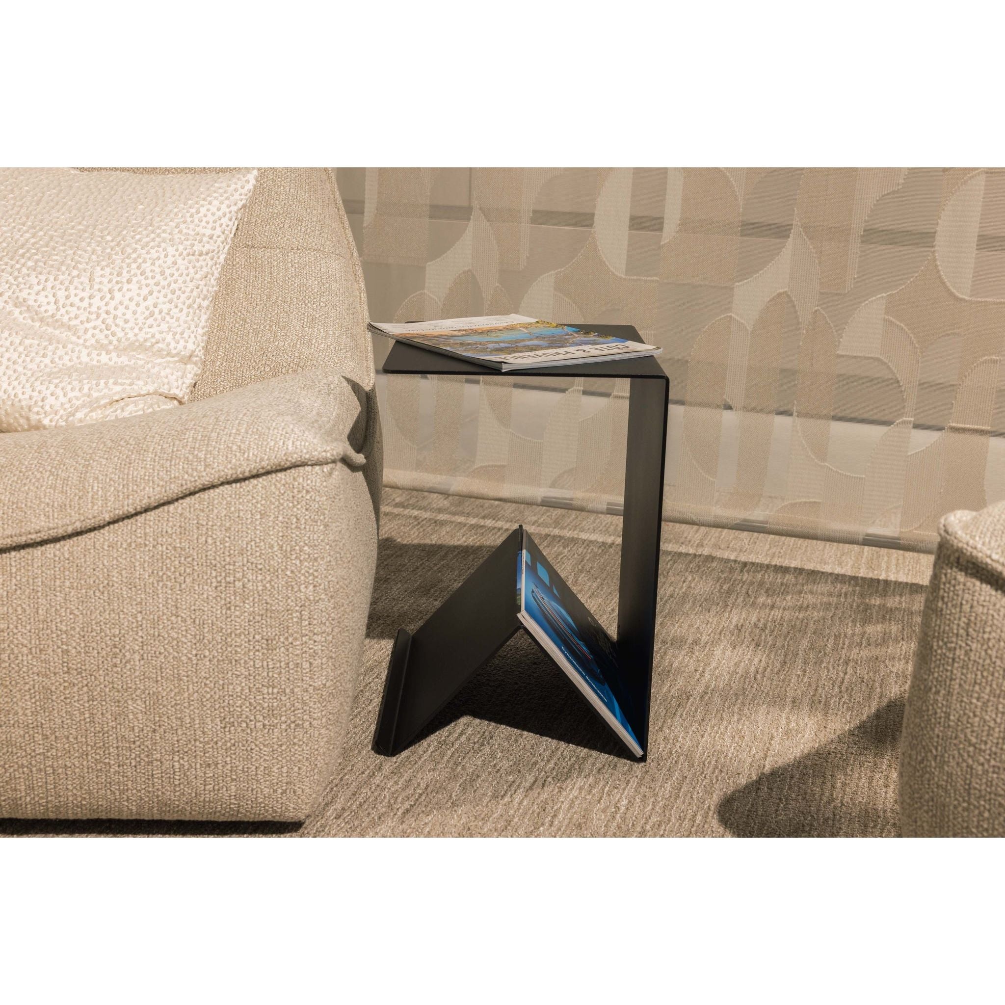 Zwarte Folda bijzettafel van Steelful in een woonkamer, strak stalen tafeltje naast de bank