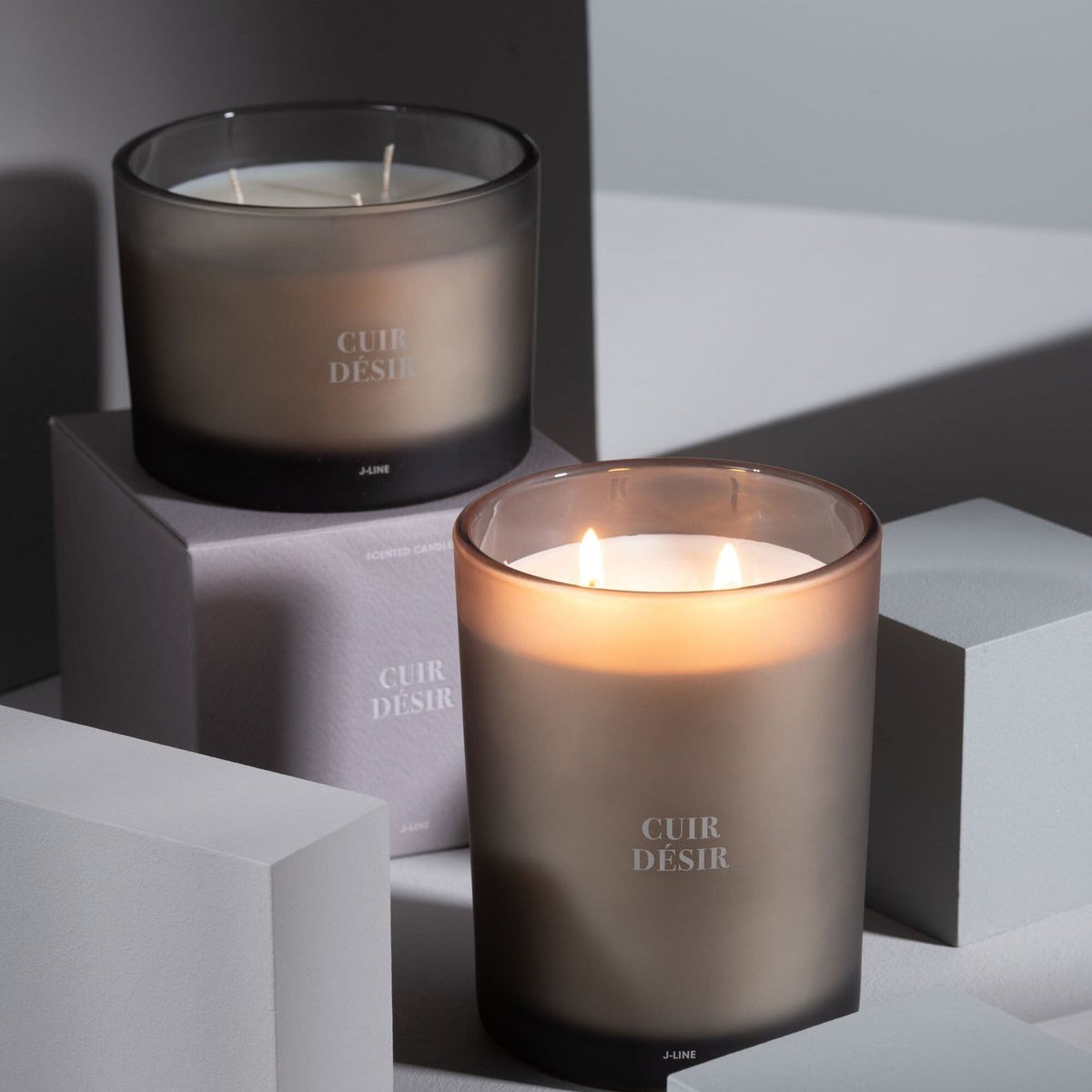 Geurkaars Accords Essentiels Cuir Désir 52 Uur van J-Line op decoratieve blokken in een warme sfeerfoto
