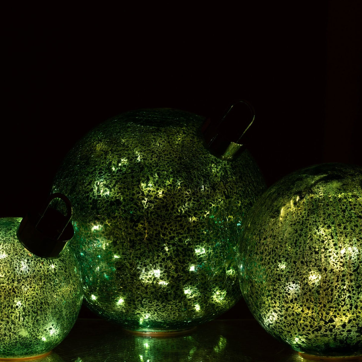 Drie brandende turquoise ledkerstballen van J-Line die samen een koele gloed geven in het donker