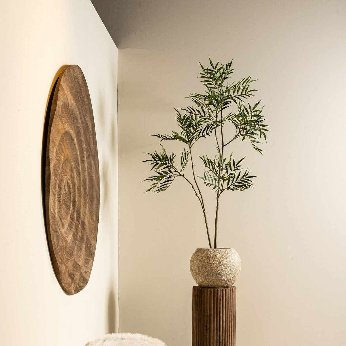 Mahonia Fortunei kunstboom van PTMD in zwarte pot in een gestylede woonkamer