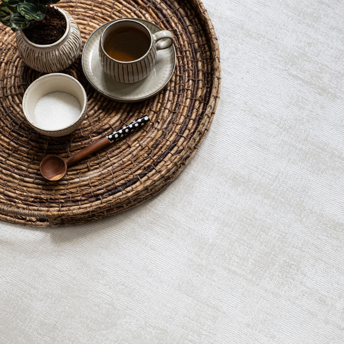 Detail van het zandkleurige La Belle vloerkleed van MUST Living met de zachte glans van viscose