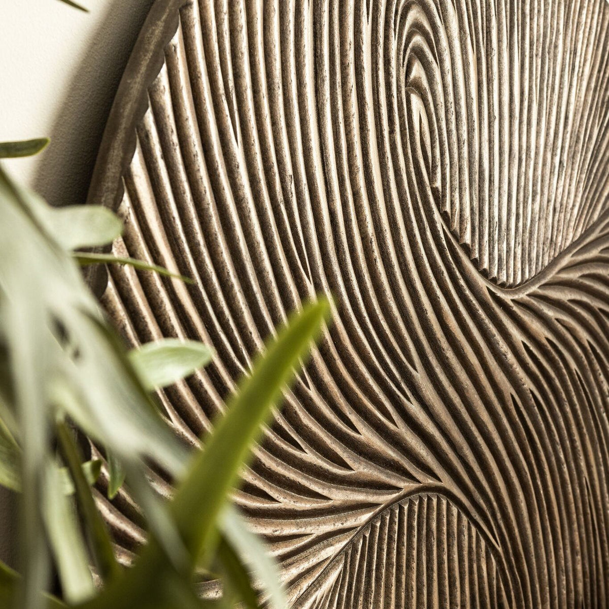 Wandpaneel Wiktor Rond Bruin Ø120cm van PTMD, close up van het uitgesneden swirlreliëf met plant
