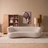 Bank Amy 3-Zits Beige van Starfurn, gebogen bank in lichte beige stof voor een kast met decoratie