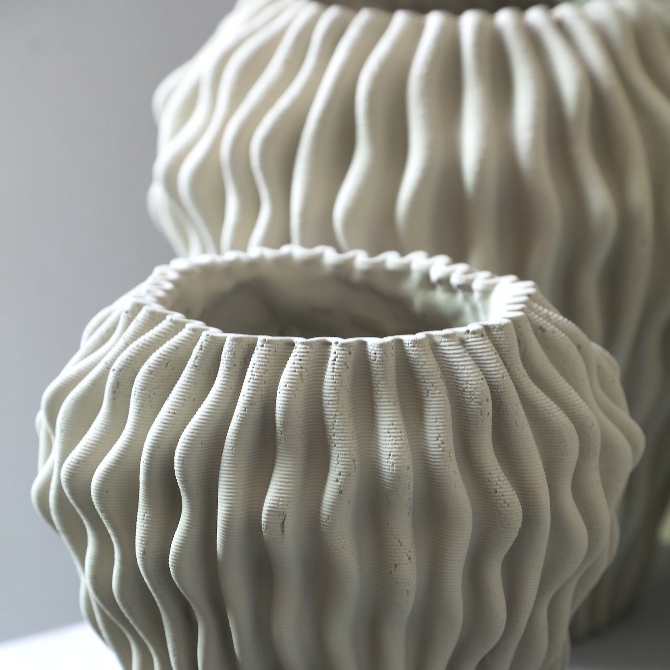 Barren Beige Cement Round Vase 3D Wavy Pattern L van PTMD, sfeerfoto op een dressoir