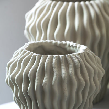 Barren Beige Cement Round Vase 3D Wavy Pattern L van PTMD, sfeerfoto op een dressoir