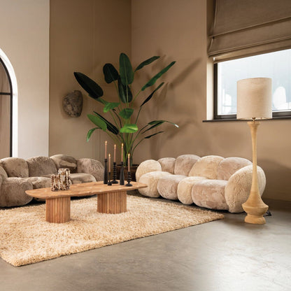Ruime woonkamer met de beige Curvae bank van PTMD, houten salontafel en groot vloerkleed