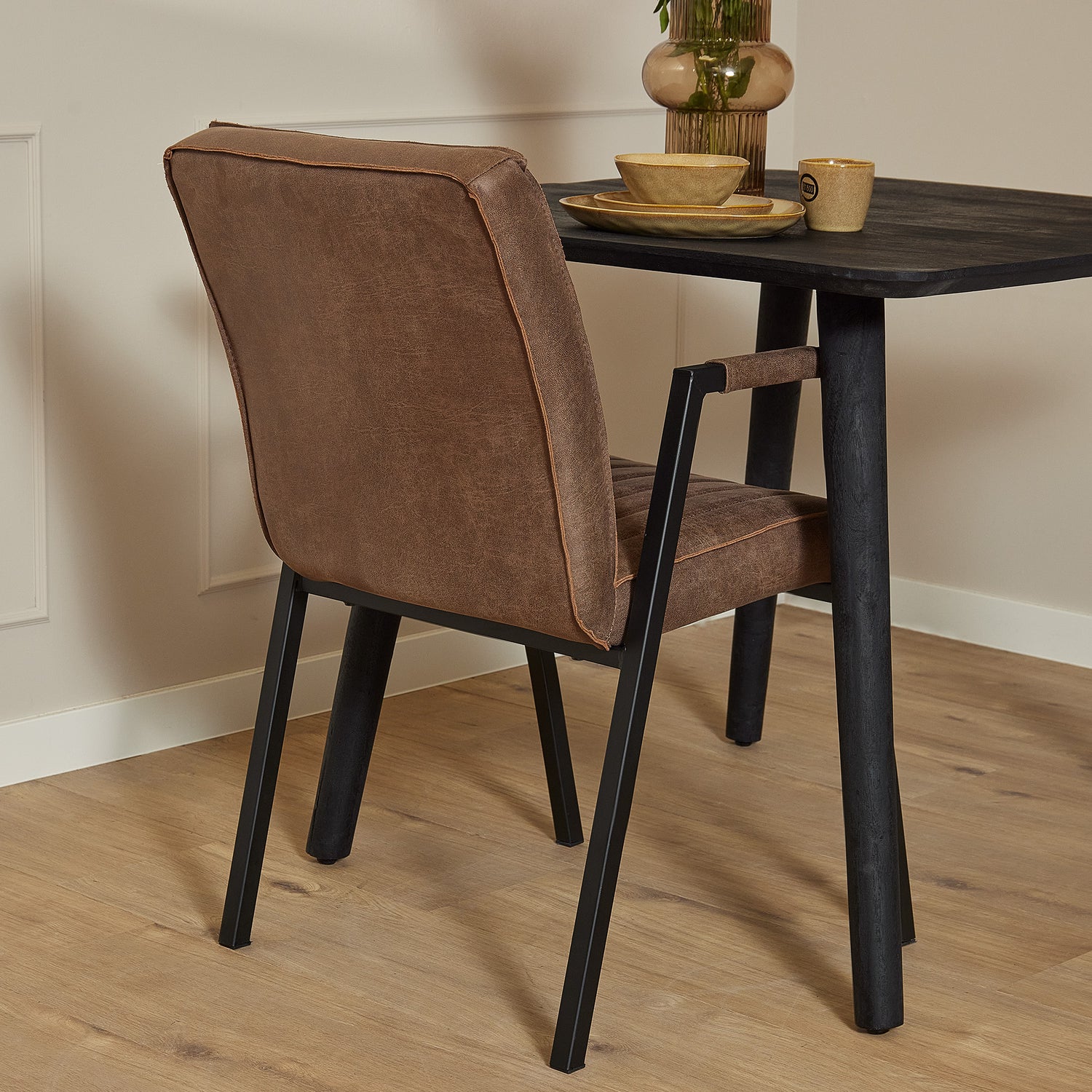 Armstoel Tivoli in warm bruin met contrasterend stiksel en mat zwart stalen frame