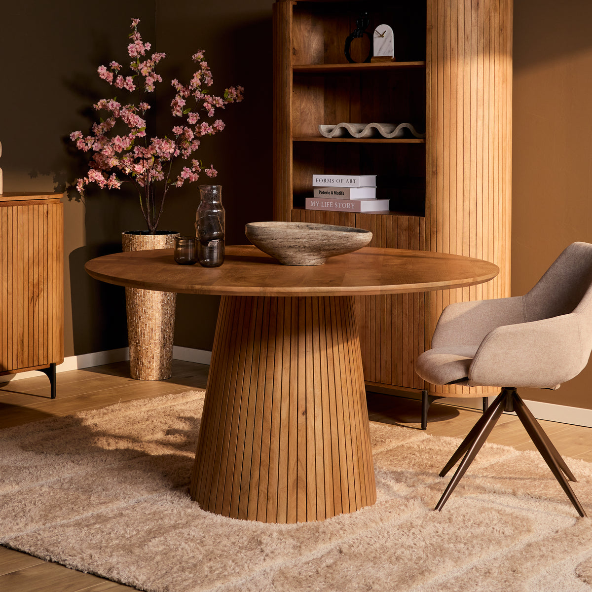 Solana eettafel naturel gedekt met een vaas bloesem voor een open kast