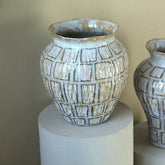 Emylee pot van PTMD gestyled in een interieur, lage witte pot met plant