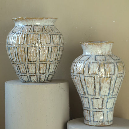 Emylee pot van PTMD in een sfeerbeeld, witte keramieken pot op de vloer