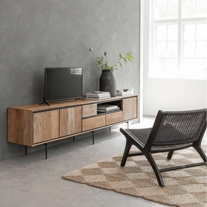 Fauteuil Lazy Loom Zwart van MUST Living in een woonkamer bij een plant en een bijzettafel