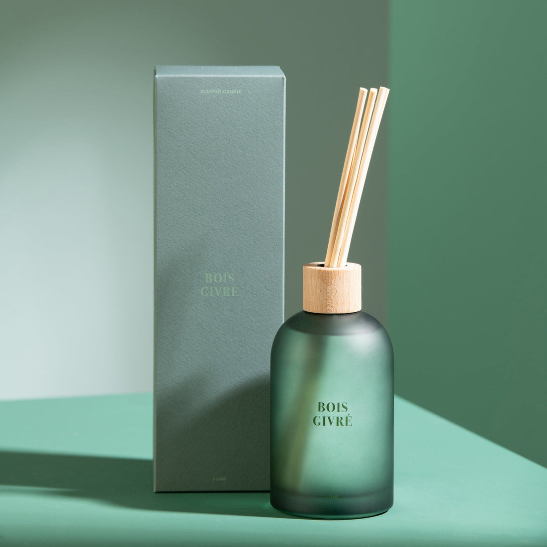 Geurstokjes Accords Essentiels Bois Givré 250ml van J-Line met bijpassende doos in een sfeervolle groene setting