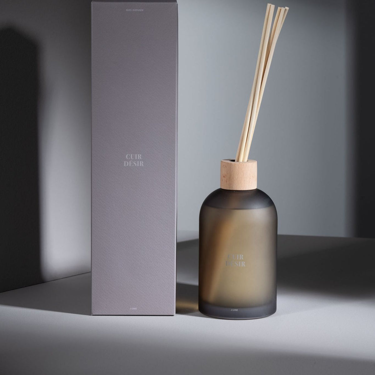 Geurstokjes Accords Essentiels Cuir Désir 550ml van J-Line met bijpassende doos in een sfeervolle bruine setting