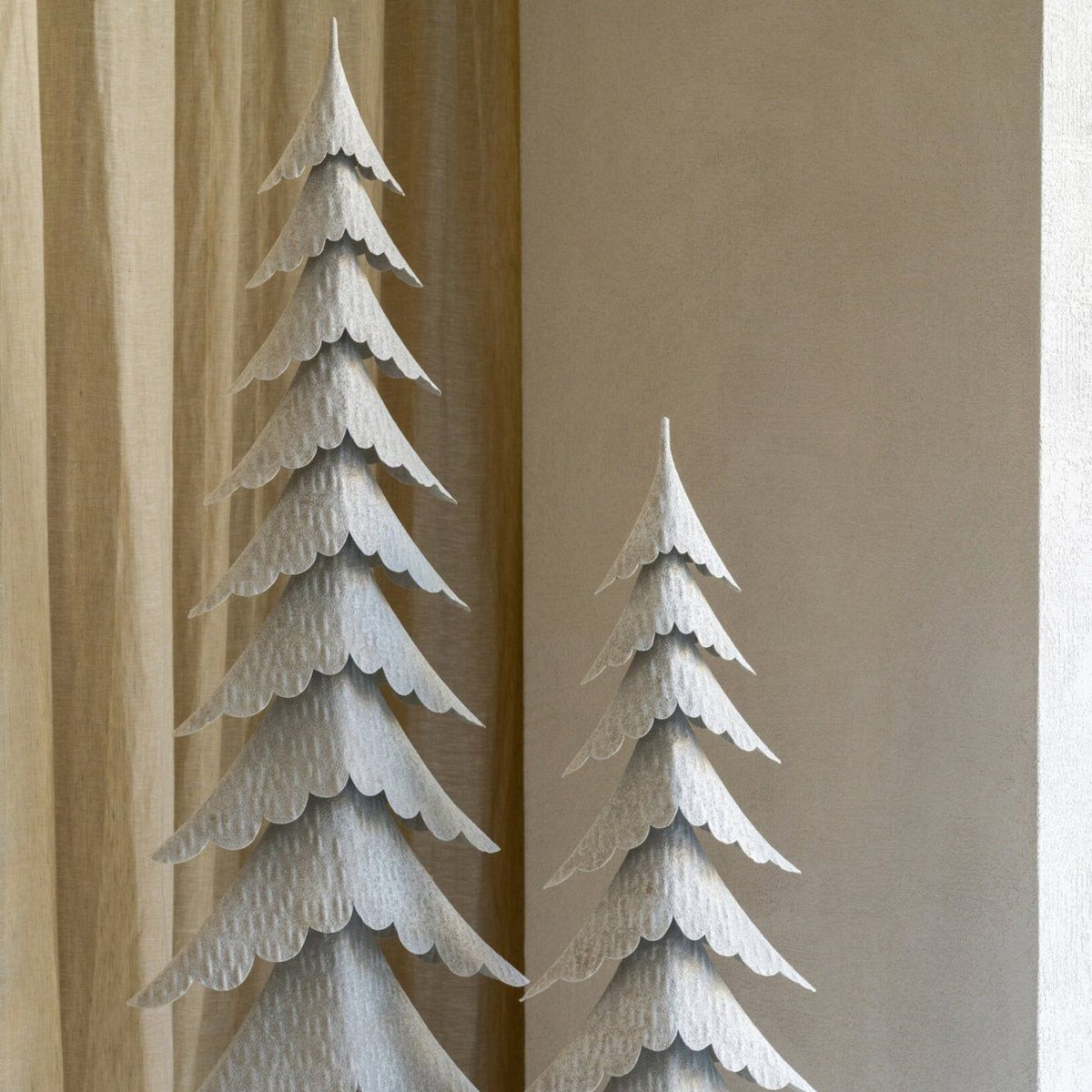 Grote witte kerstboom op stam van J-Line gestyled in een licht interieur