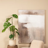 Kunstmonstera van PTMD gestyled in een lichte woonkamer naast een bank