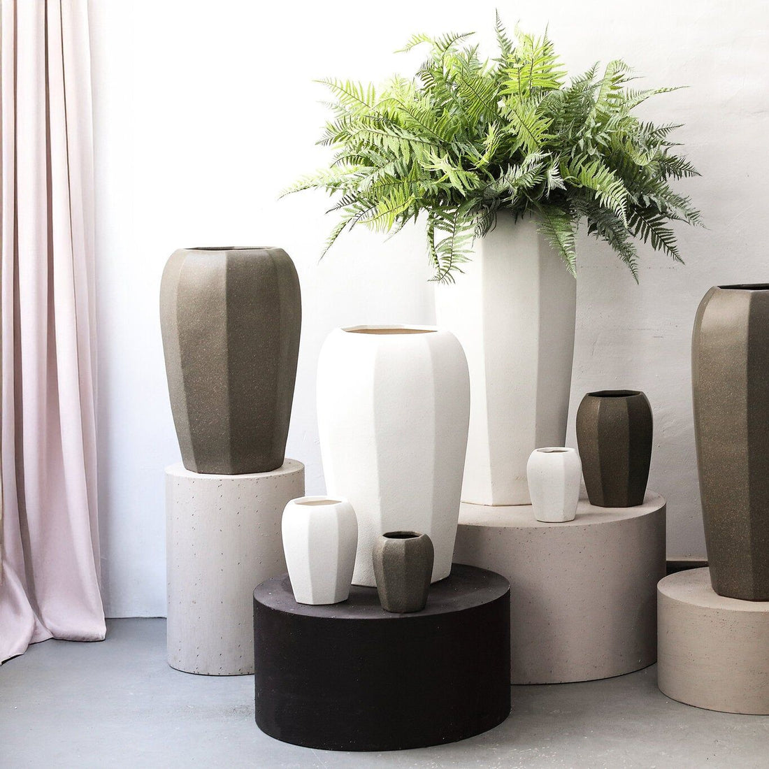 Myrick pot XL van PTMD in een woonsetting, donkerbruine pot met grote plant