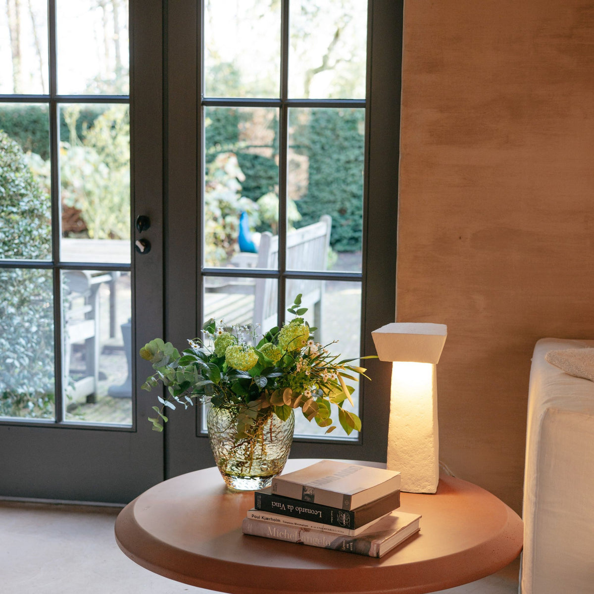 Salontafel Carva Rond Vezelcement Baksteenrood van Pomax, sfeerbeeld met styling in huis