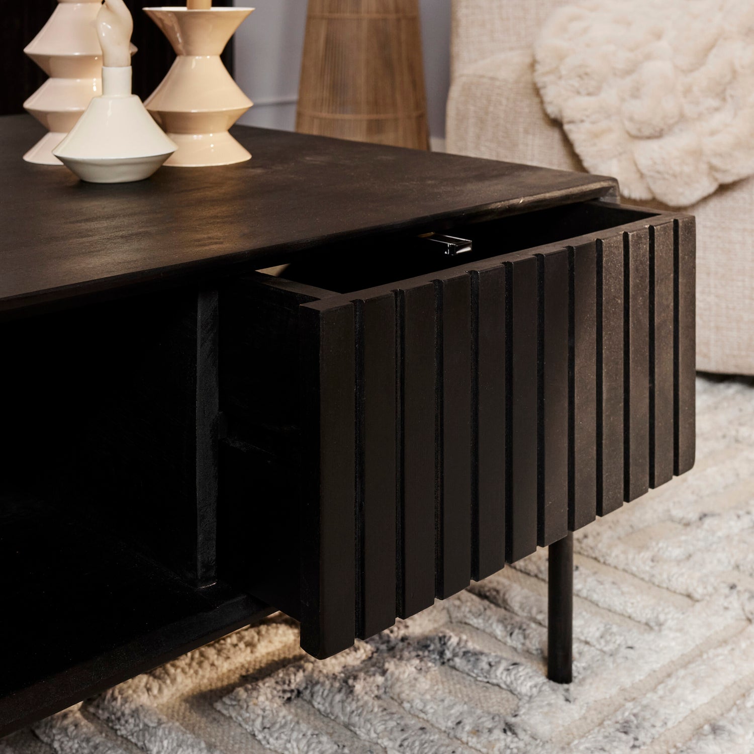Detail van het verticale lattenpatroon op de zwart gelakte lades van de Madison salontafel