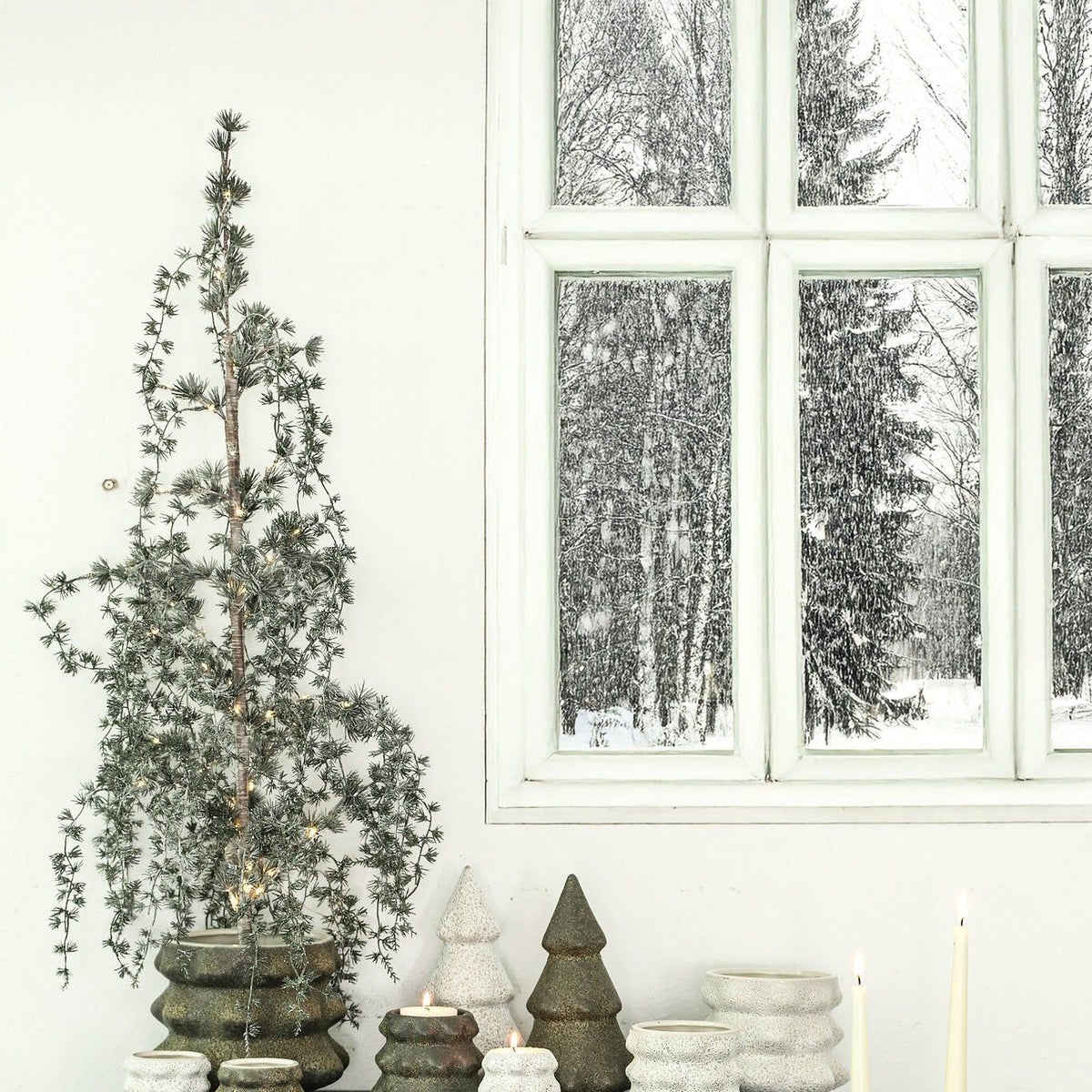 Set Van 2 Malin Kerstbomen Keramiek Wit Hoekig van PTMD, sfeerbeeld met keramieken kerstboompjes op een donkergroene kast