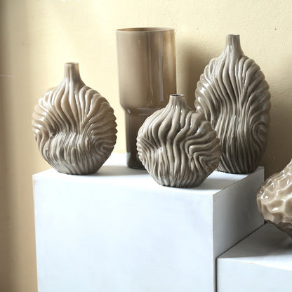 Set Van 3 Kelline Glazen Vazen Ribbel van PTMD, de taupe vaas small in een woonkamer