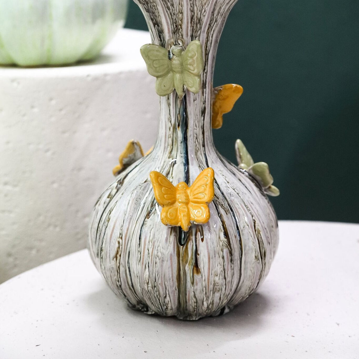 Tamarae Cream Ceramic Flowy Vase With Butterfly L van PTMD, gestyled met bloemen in een woonkamer