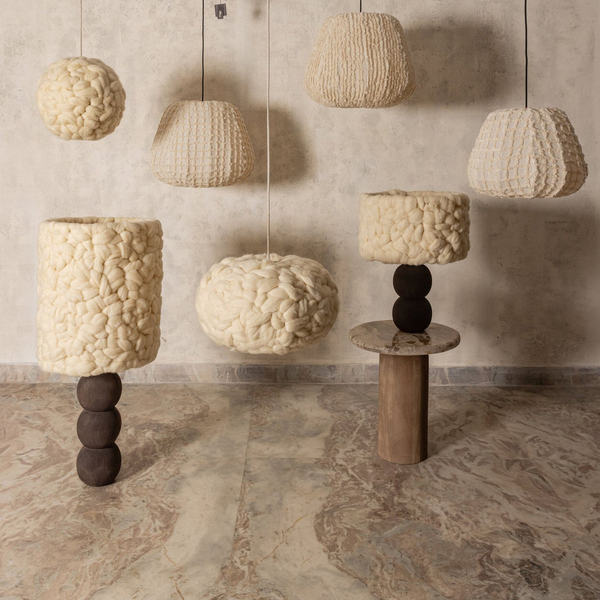 Sfeerfoto Tayma collectie van PTMD, hanglampen van crème katoen boven sculpturale tafellampen