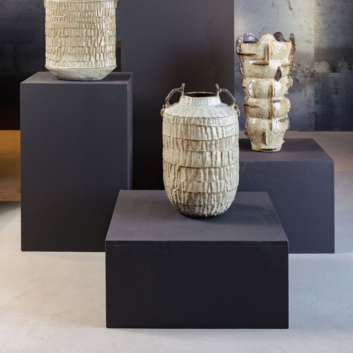 Telise amfoorvaas van PTMD in een sfeerbeeld, beige keramiek naast meubilair
