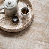 Vloerkleed La Belle van MUST Living, sfeerbeeld van het beige viscose vloerkleed in een lichte woonkamer