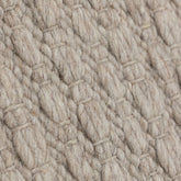 Vloerkleed Nirvana van MUST Living, detailfoto van de dikke gevlochten wolstructuur in beige