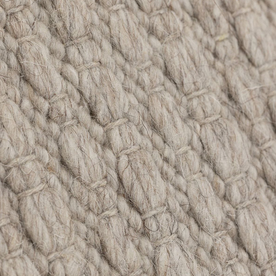 Vloerkleed Nirvana van MUST Living, detailfoto van de dikke gevlochten wolstructuur in beige