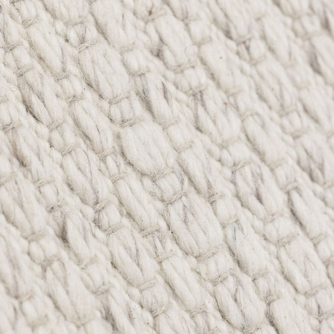 Vloerkleed Nirvana van MUST Living, detailfoto van de dikke gevlochten wolstructuur in ivoor