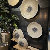 Wandpaneel Vojtech Wit Schelpen Bamboe Medium van PTMD, drie schelpenpanelen aan een donkere muur met planten