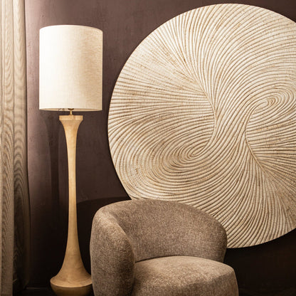 Wandpaneel Wiktor Rond Wit Ø180cm van PTMD aan een donkere muur naast een vloerlamp en fauteuil