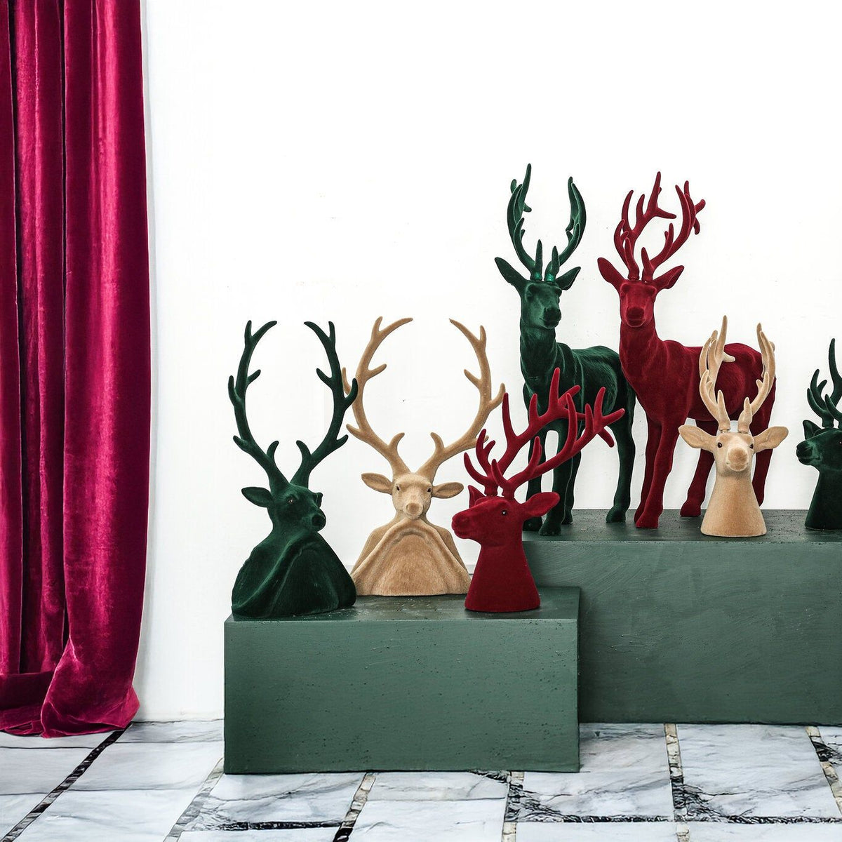 Yule Rendierkop Donkergroen Small van PTMD, rendieren en kerstboompjes in drie kleuren op een groene kast