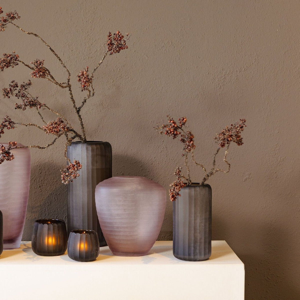 Zalia vaas van PTMD in een woonsetting, roze glazen vaas op tafel